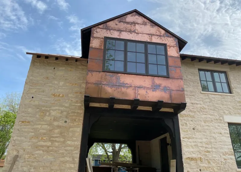 Copper metal panel facade on a stone building for Skylight Installation in Makawao